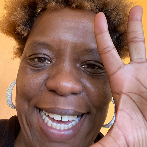 a Black woman holding up an open hand