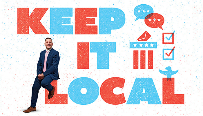 J. Christian Dumais '02 on a banner that says "Keep It Local"