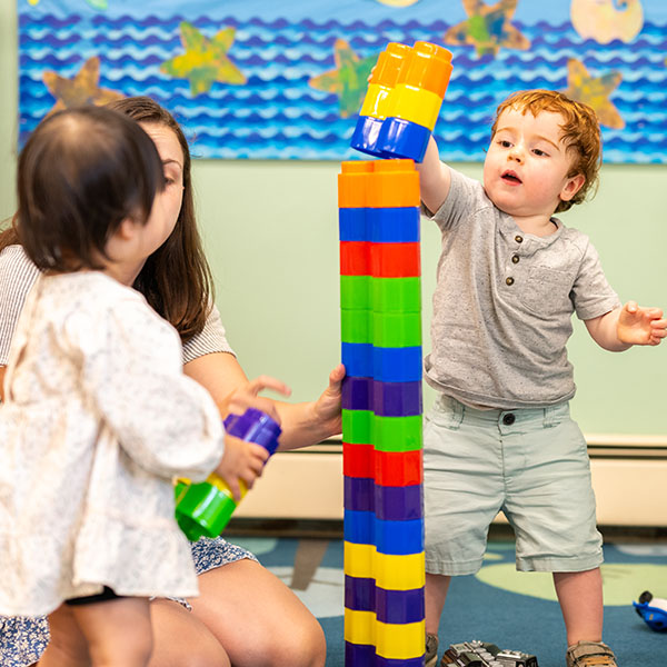 toddler boy building a block tower