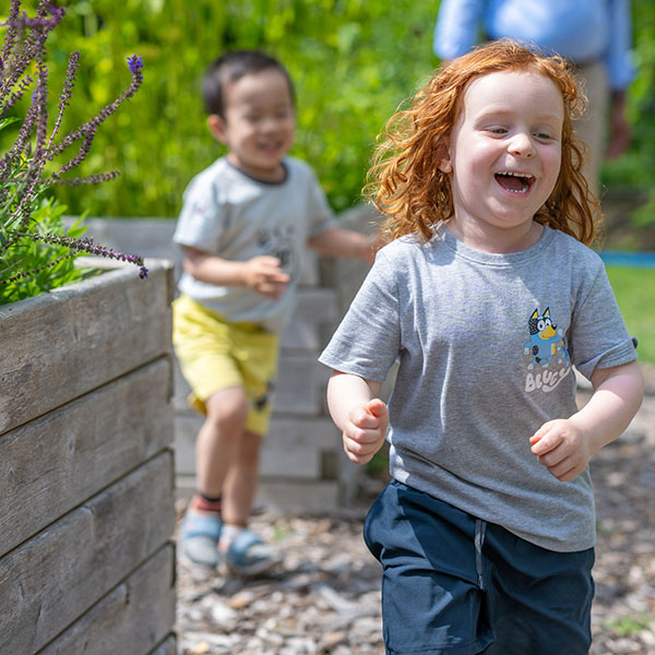 preschool children running in a garden