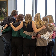 students in a huddle while in a classroom