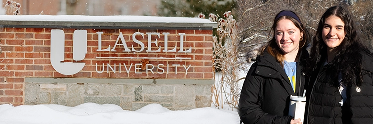 Orientation leaders around Lasell brick sign