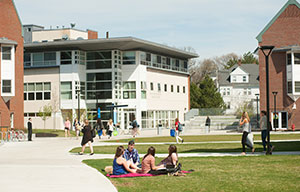 students sitting on grass outside dorms