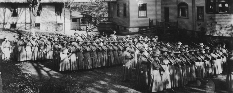 Women carrying rifles, marching in a military formation